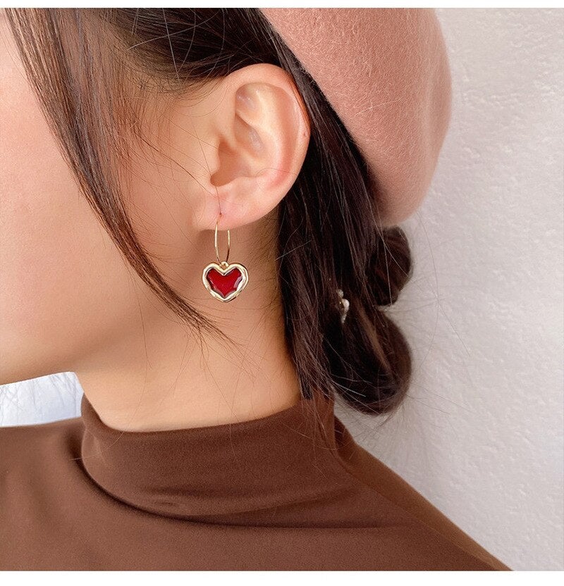 Brincos com pingente de coração vermelho